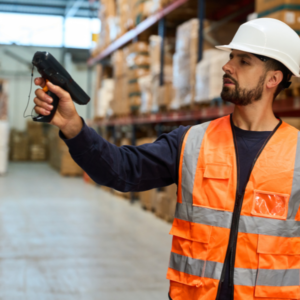 Een magazijnmedewerker in bedrijfskleding scant voor het eerst een barcode op een product voor eenvoudige registratie