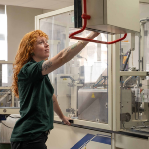 Medewerkster Pieterpik heeft ingeklokt en staat bij een productiemachine